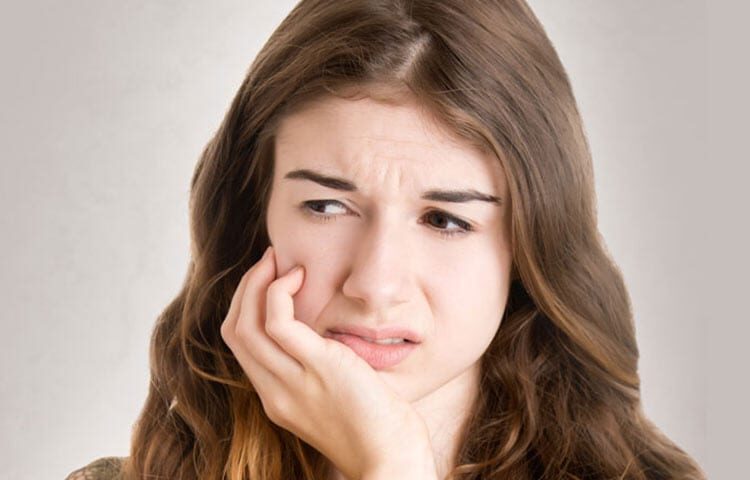 Bothered Lady Suffering from Dental Pain | TMJ, Teeth Grinding Treatment in West Liberty, IA, North Liberty, IA and Muscatine, IA | Gentle Family Dentists