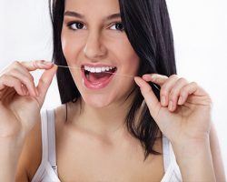 Lady Flossing Her Upper Front Teeth | Dental Prevention in West Liberty, IA, North Liberty, IA and Muscatine, IA | Gentle Family Dentists